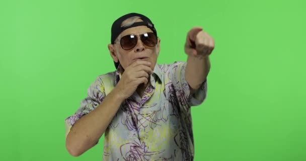 Ein älterer Herr mit Sonnenbrille deutet auf etwas. schöner alter Mann — Stockvideo