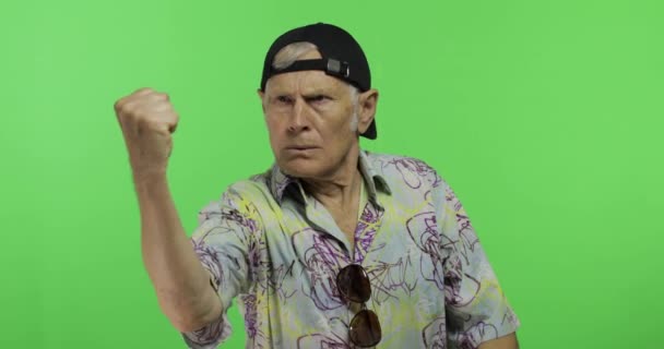 Старший чоловік туристичні сварки на когось небезпечно рухається своїми руками кулаком — стокове відео