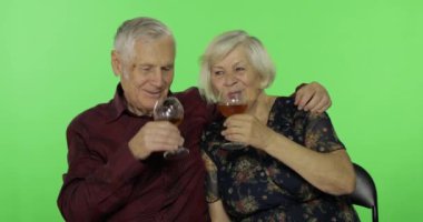 Büyük yaşlı adam Chroma anahtar üzerinde yaşlı bir kadın arkadaşı ile beyaz şarap içme