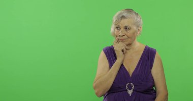 Yaşlı bir kadın bir şey düşünüyor. Eski düşünceli büyükanne. Chroma anahtarı