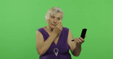 Yaşlı bir kadın makyaj yapar. Yaşlı güzel Büyükanne. Chroma anahtarı