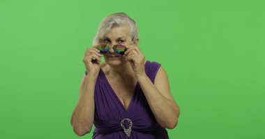 Güneş gözlüğü olan yaşlı bir kadın gülümsüyor. Yaşlı büyükanne. Chroma anahtarı