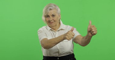 Yaşlı bir kadın başparmak yukarı göstermek ve gülümsüyor. Yaşlı büyükanne. Chroma anahtarı