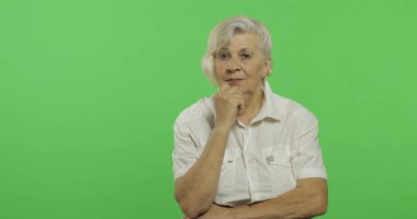 Yaşlı bir kadın bir şey düşünüyor. Eski düşünceli büyükanne. Chroma anahtarı