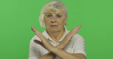 Yaşlı bir kadın bir durak, yasak jest gösterir. Yaşlı büyükanne. Chroma anahtarı