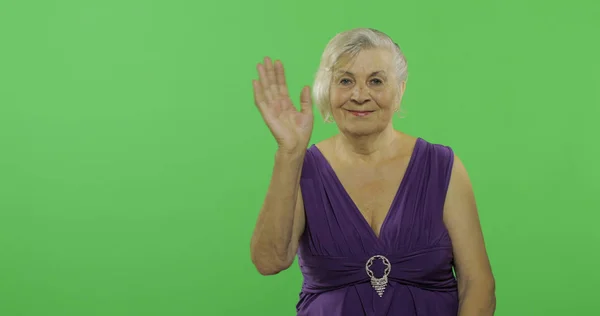 Una anciana saludando a la cámara y sonriendo. Vieja abuela. Clave de croma — Foto de Stock