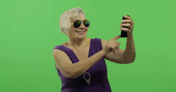 Starsza kobieta zrobić zdjęcie na smartfonie. Selfie. Klucz chrominancji — Zdjęcie stockowe