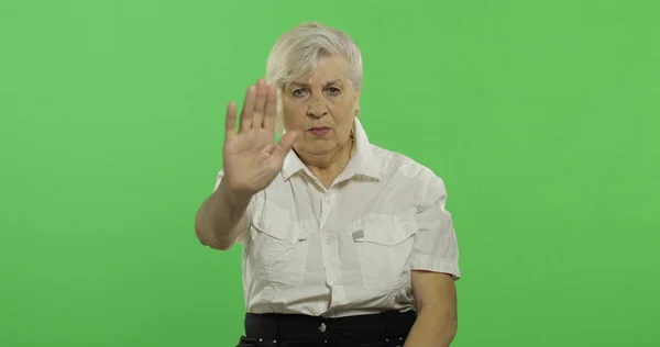Starsza kobieta pokazuje gest zatrzymania. Stara babcia. Klucz chrominancji — Zdjęcie stockowe