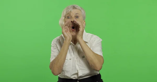 Uma idosa grita. Velha avó bonita com uma camisa branca. Chave Chroma — Fotografia de Stock
