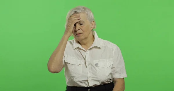 Une femme âgée souffre de maux de tête douleur trouble. Vieille grand-mère. Clé chromatique — Photo