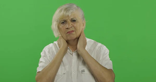 Μια ηλικιωμένη γυναίκα που έχει πόνο στο λαιμό. Η γριά γιαγιά. Πλήκτρο αποχρώσεων — Φωτογραφία Αρχείου