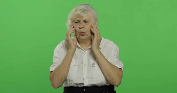 Een oudere vrouw lijdt aan hoofdpijn pijn problemen. Oude grootmoeder. Chroma Key — Stockfoto