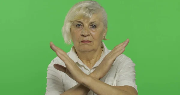 Une femme âgée montre un geste d'arrêt, interdit. Vieille grand-mère. Clé chromatique — Photo