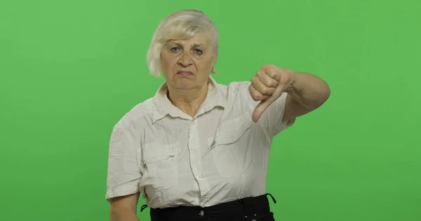 En äldre kvinna visar Nej och ger tummen ner. Mormor. Chroma Key — Stockfoto