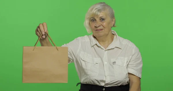 Eine ältere Frau mit Einkaufstasche. Einkaufen. Geschenke. Chroma-Schlüssel — Stockfoto