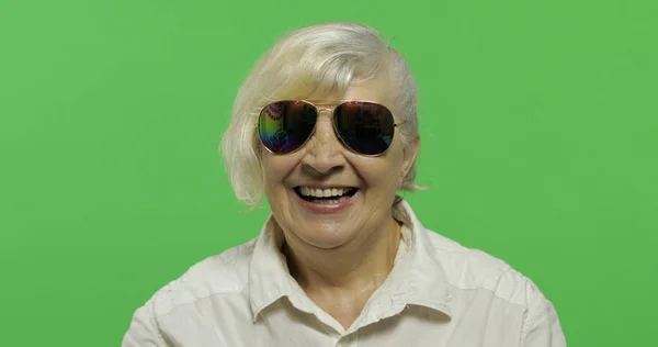 Una anciana con gafas de sol sonríe. Clave de croma —  Fotos de Stock
