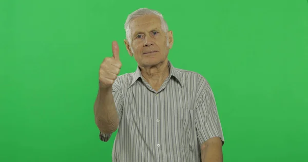 Senior man Toon duim omhoog en glimlacht. Knappe oude man op chroma key achtergrond — Stockfoto