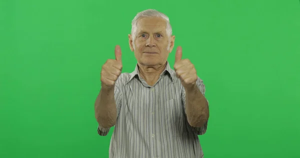 O senhor mostra o polegar e sorri. Bonito homem velho no fundo da chave chroma — Fotografia de Stock