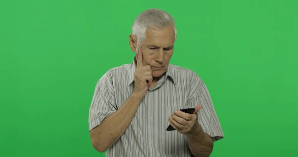 Senior man werkt op een smartphone. Knappe oude man op chroma key achtergrond — Stockfoto