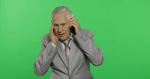 ハンサムな年配のビジネスマンがスマートフォンで話す。スーツを着た老人 — ストック写真