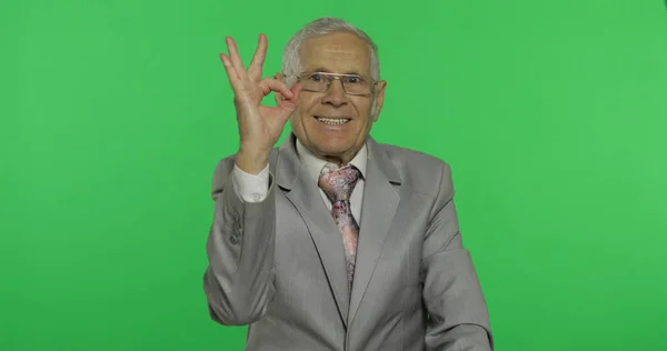 Elderly businessman showing ok gesture. Old man in formal wear giving okay sign
