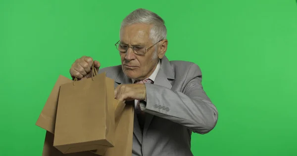Oudere zakenman met boodschappentassen. Oude man in formele slijtage na het winkelen — Stockfoto