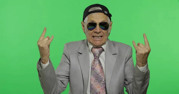 Divertente anziano uomo d'affari in occhiali da sole mostrano segno delle corna con le mani — Foto Stock