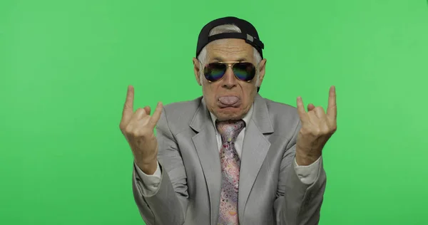 Homme d'affaires âgé drôle dans les lunettes de soleil montrent signe des cornes avec ses mains — Photo