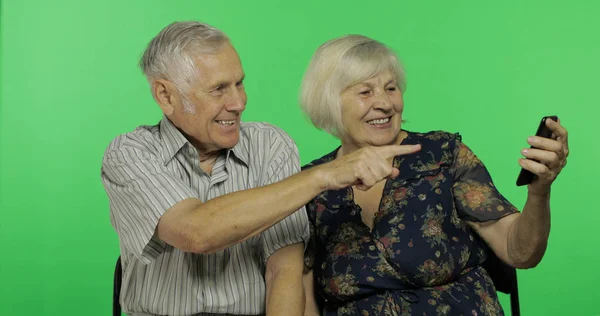 Senior aged man and woman having video chat using smartphone. Chroma key — Stock Photo, Image