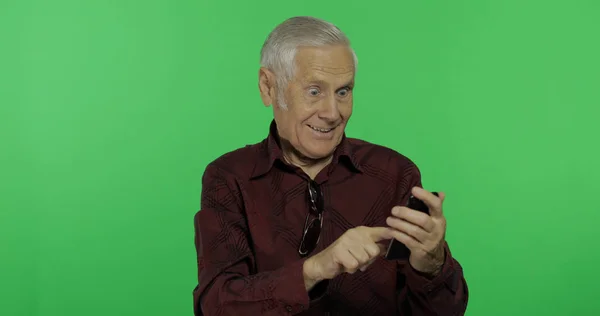 Senior man Tourist werkt op een smartphone op chroma key achtergrond — Stockfoto