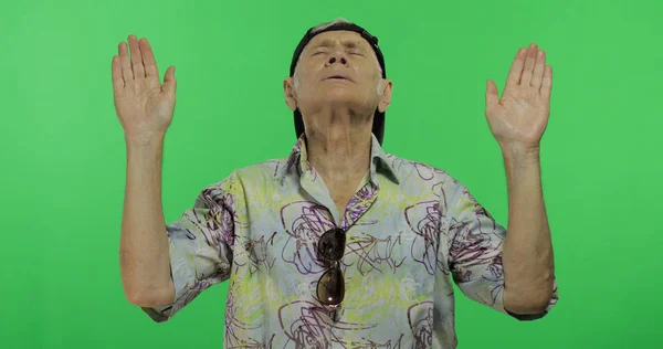 Senior man toerist in kleurrijke shirt doen meditatie. Knappe oude man — Stockfoto