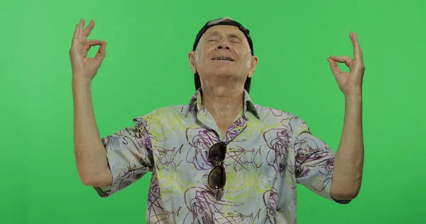 Senior man tourist in colorful shirt doing meditation. Handsome old man — Stock Photo, Image