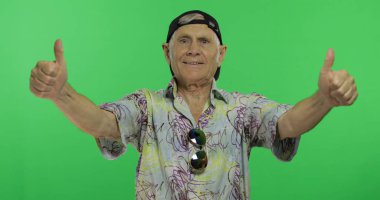 Kıdemli adam turist gösterisi başparmak yukarı ve gülümsüyor. Yakışıklı eski adam üzerinde Chroma anahtar