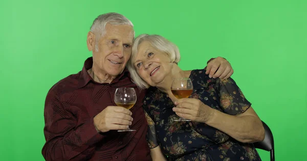 Мужчина старшего возраста пьет белое вино с пожилой женщиной-компаньонкой на хрома-ключе — стоковое фото