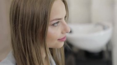 Güzel kadın model gülümsüyor ve salonda saç kesimi önce kamera bakıyor