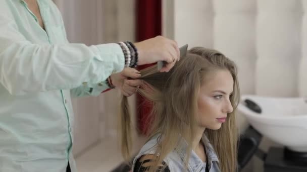 Professionele kapper die werkt met model Hair. Rechttrekken van gegolfd ijzer — Stockvideo