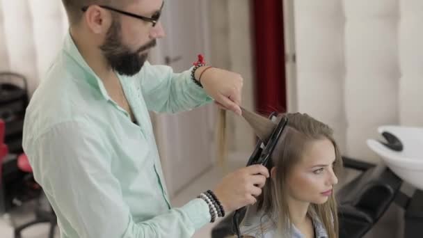 Peluquería profesional que trabaja con el cabello modelo. Enderezamiento de hierro corrugado — Vídeos de Stock