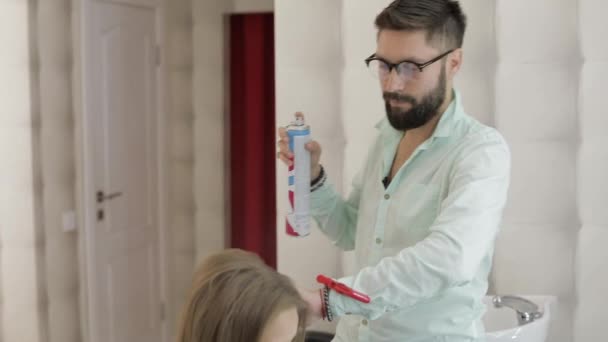 Professional κομμωτής προσθέτει βερνίκι μαλλιών για τα μαλλιά μοντέλο. Χτένισμα έντασης — Αρχείο Βίντεο