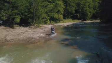 Aşırı motosikletçi nehir yakınında sürmek. Motocross. Motosport.