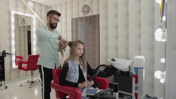 Coiffeur professionnel travaillant avec des cheveux de modèle. Redressement du fer ondulé — Video