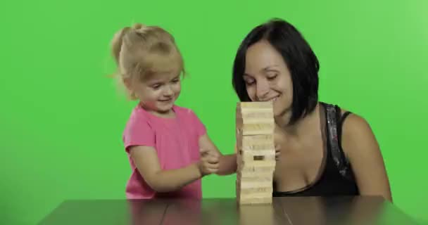 Mutter und Tochter spielen das Jenga. Kind zieht Holzklötze vom Turm — Stockvideo