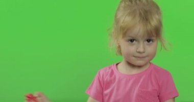 Mutlu küçük kız kroma anahtar arka plan üzerinde plasticine ile oynar