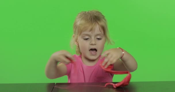 Mutlu küçük kız kroma anahtar arka plan üzerinde plasticine ile oynar — Stok video