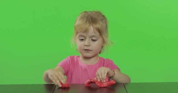 Счастливая маленькая девочка играет с пластилином на фоне хрома ключ — стоковое видео
