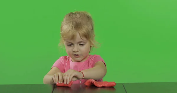 幸せな小さな女の子はクロマキーの背景にプラスチックで遊ぶ — ストック写真