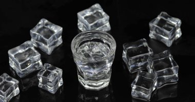 Siyah arka plan karşı buz küpleri ile votka Shot