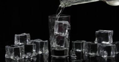 Şişeden bardağa bir bardak votka döküyorum. Siyah arka plan