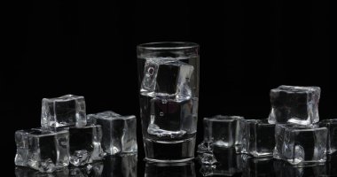Siyah arka plan karşı buz küpleri ile votka Shot