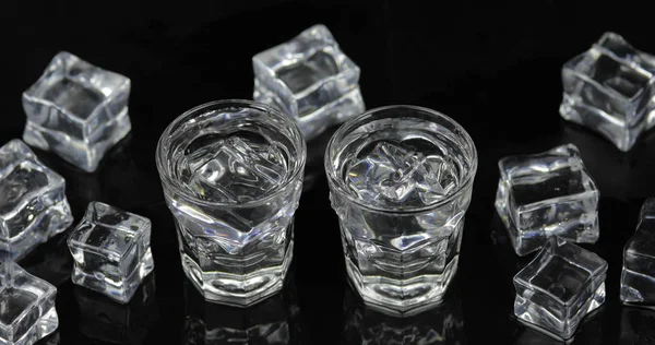 Colpi di vodka con cubetti di ghiaccio sullo sfondo nero — Foto Stock