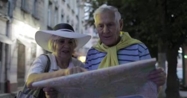 Üst düzey erkek ve kadın turistler yol arıyor elinde bir harita ile ayakta